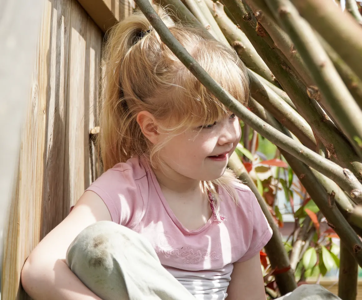 Kind speelt buiten in Wilgentakken huisje bij gastouder van kinderopvang Kind&co ludens