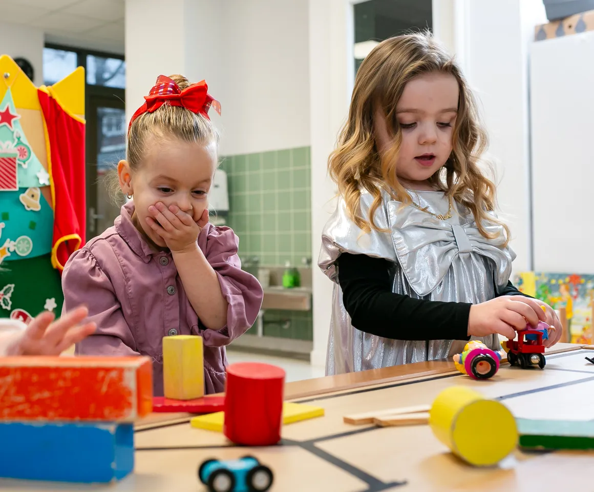 Kinderen van de peutergroep lachen en spelen samen bij kinderopvang Kind&co ludens