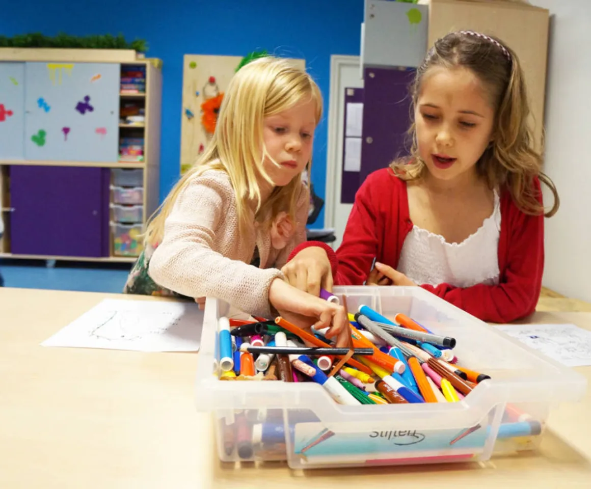 Kinderen kleuren een kleurplaat bij buitenschoolse opvang Kameleon, kinderopvang Kind&co Ludens