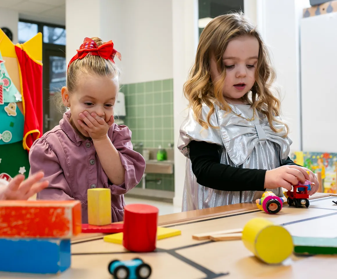 Kinderen van de peutergroep lachen en spelen samen bij kinderopvang Kind&co ludens