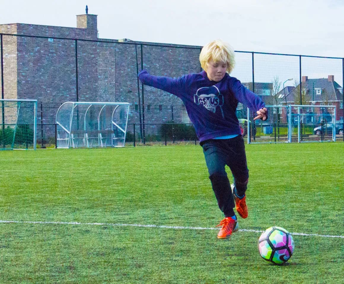 Kind aan het voetballen bij BSO Woerden De Stein van kinderopvang Kind&co ludens