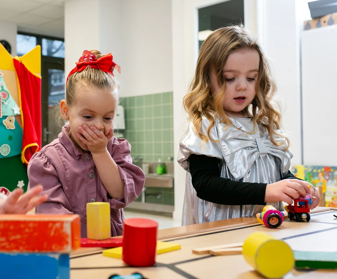 Kinderen van de peutergroep lachen en spelen samen bij kinderopvang Kind&co ludens