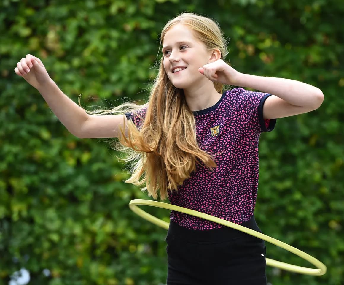 Kind van de BSO hoepelt buiten bij kinderopvang Kind&co ludens