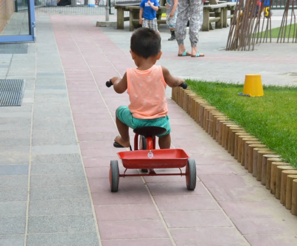 Kind buiten fietsend op driewieler bij Kinderdagverblijf Abcoude Piet Mondriaan van kinderopvang Kind&co ludens