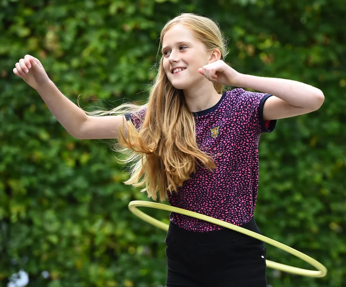 Kind van de BSO hoepelt buiten bij kinderopvang Kind&co ludens