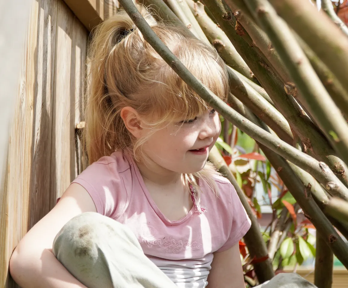 Kind speelt buiten in Wilgentakken huisje bij gastouder van kinderopvang Kind&co ludens