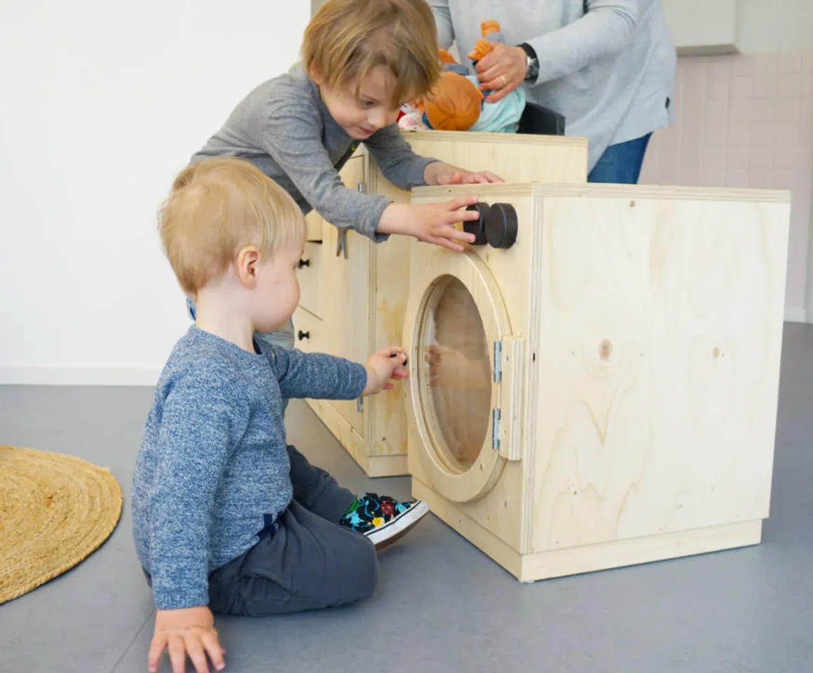 Kinderen spelen met een speelgoedwasmachine bij Kinderdagverblijf Abcoude Droomboom van kinderopvang Kind&co ludens