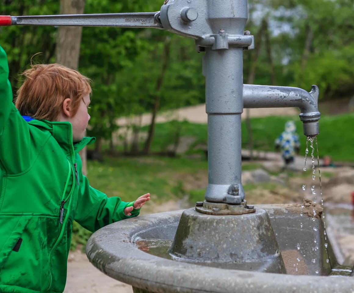 Kind speelt buiten met water bij BSO Utrecht Maan van kinderopvang Kind&co ludens