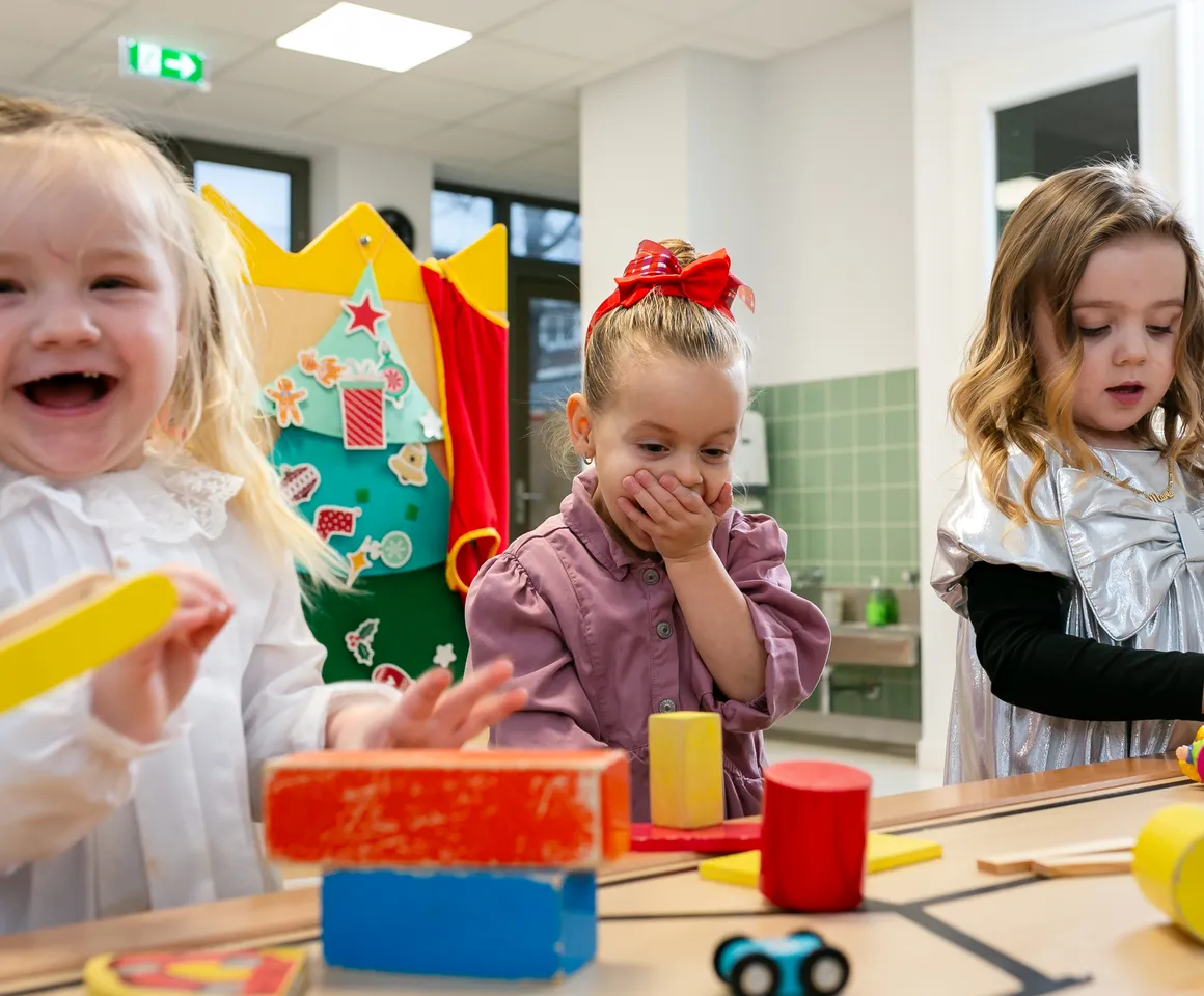 Kinderen van de peutergroep lachen en spelen samen bij kinderopvang Kind&co ludens