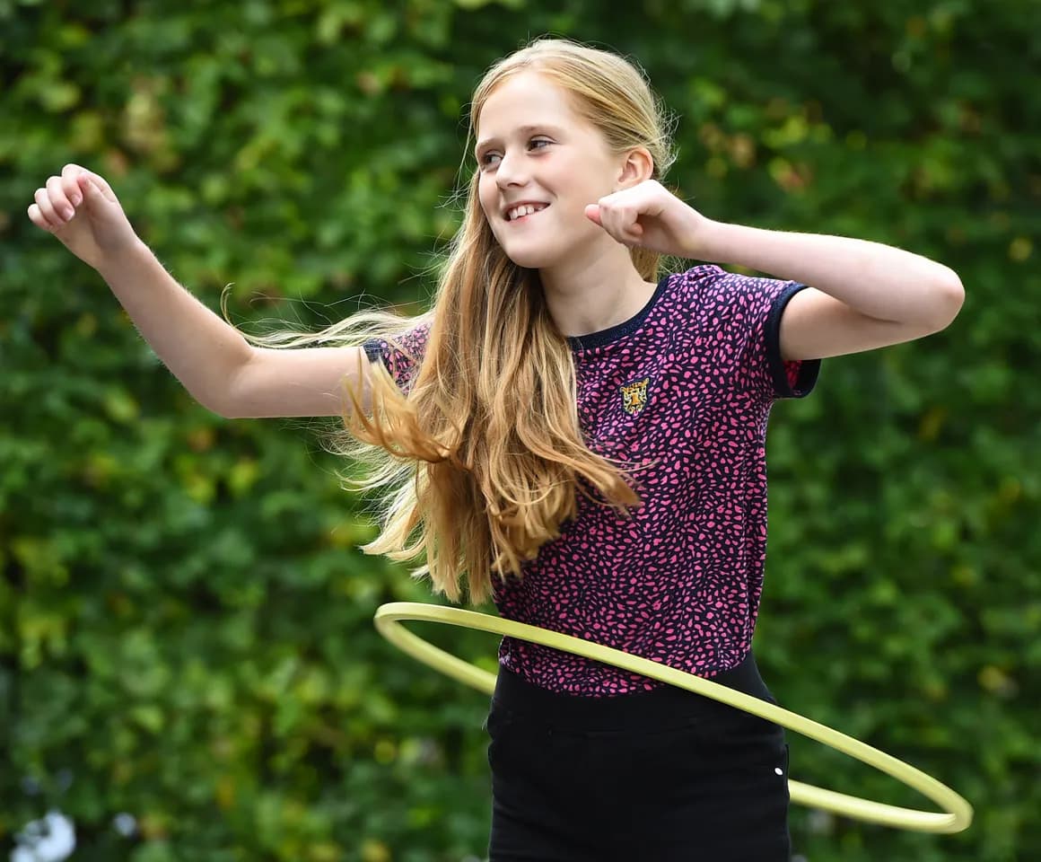 Kind van de BSO hoepelt buiten bij kinderopvang Kind&co ludens