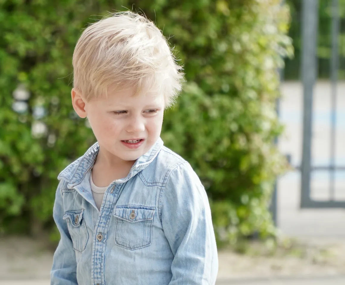 Kind staat buiten bij de heg bij gastouder van kinderopvang Kind&co ludens