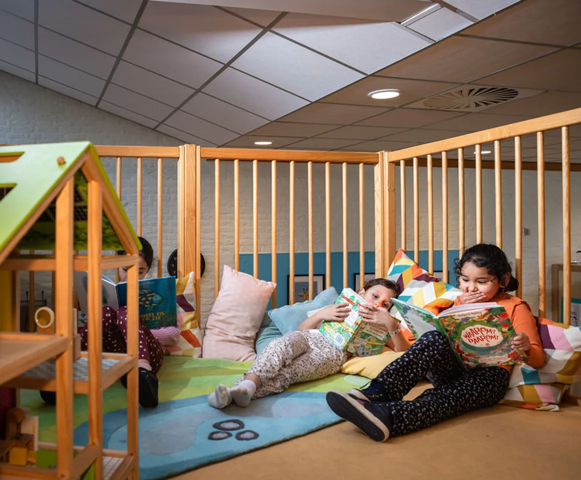 Kinderen lezen een boek in de boekenhoek van buitenschoolse opvang Villa Kofschip, kinderopvang Kind&co Ludens