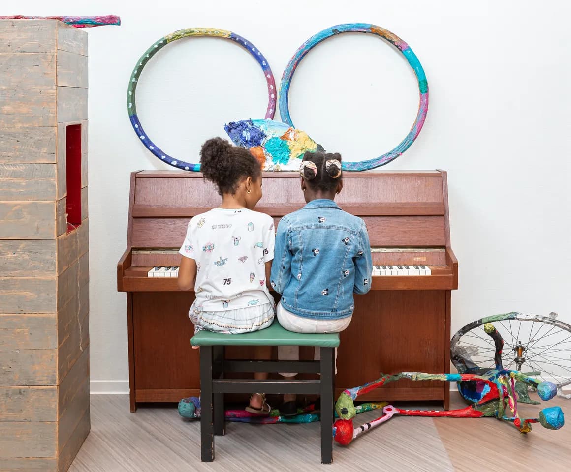 Kinderen spelen samen op de piano bij de BSO van kinderopvang Kind&co ludens