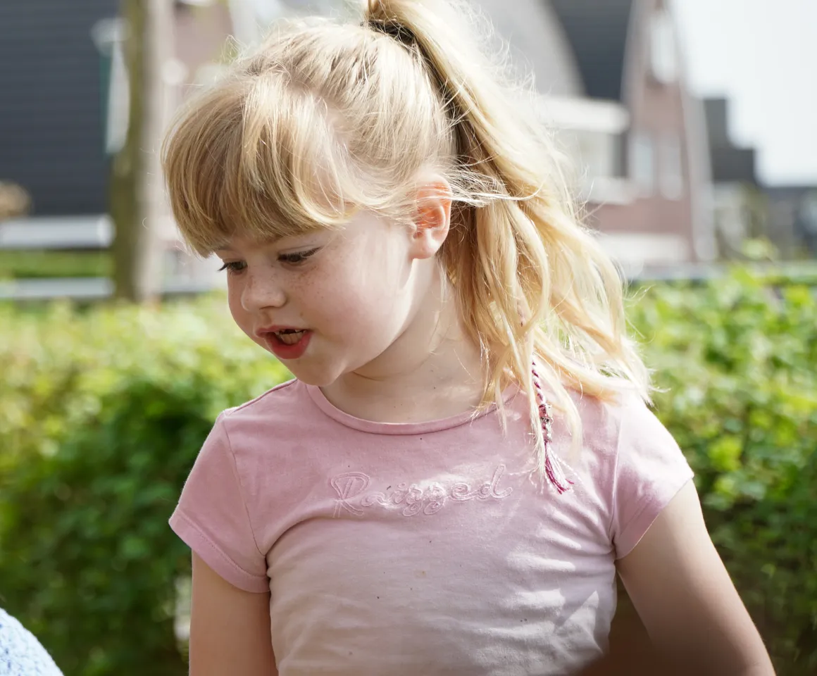 Kind voor de heg met gastouder van kinderopvang Kind&co ludens