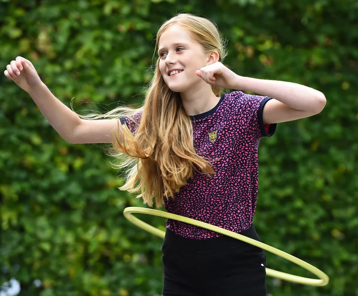 Kind van de BSO hoepelt buiten bij kinderopvang Kind&co ludens