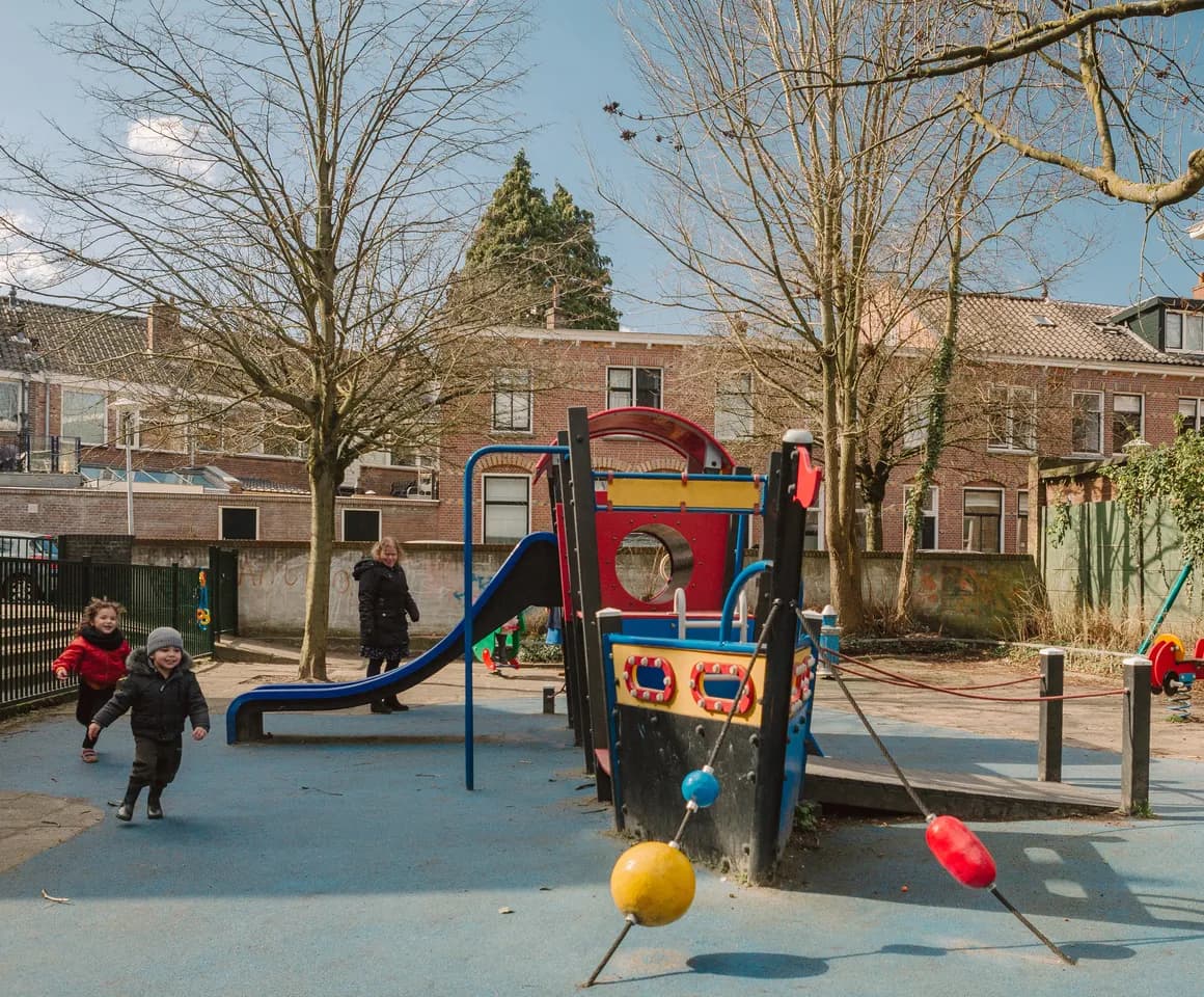 Kinderen spelen buiten bij de klimboot bij peuteropvang Warmoes, kinderopvang Kind&co ludens