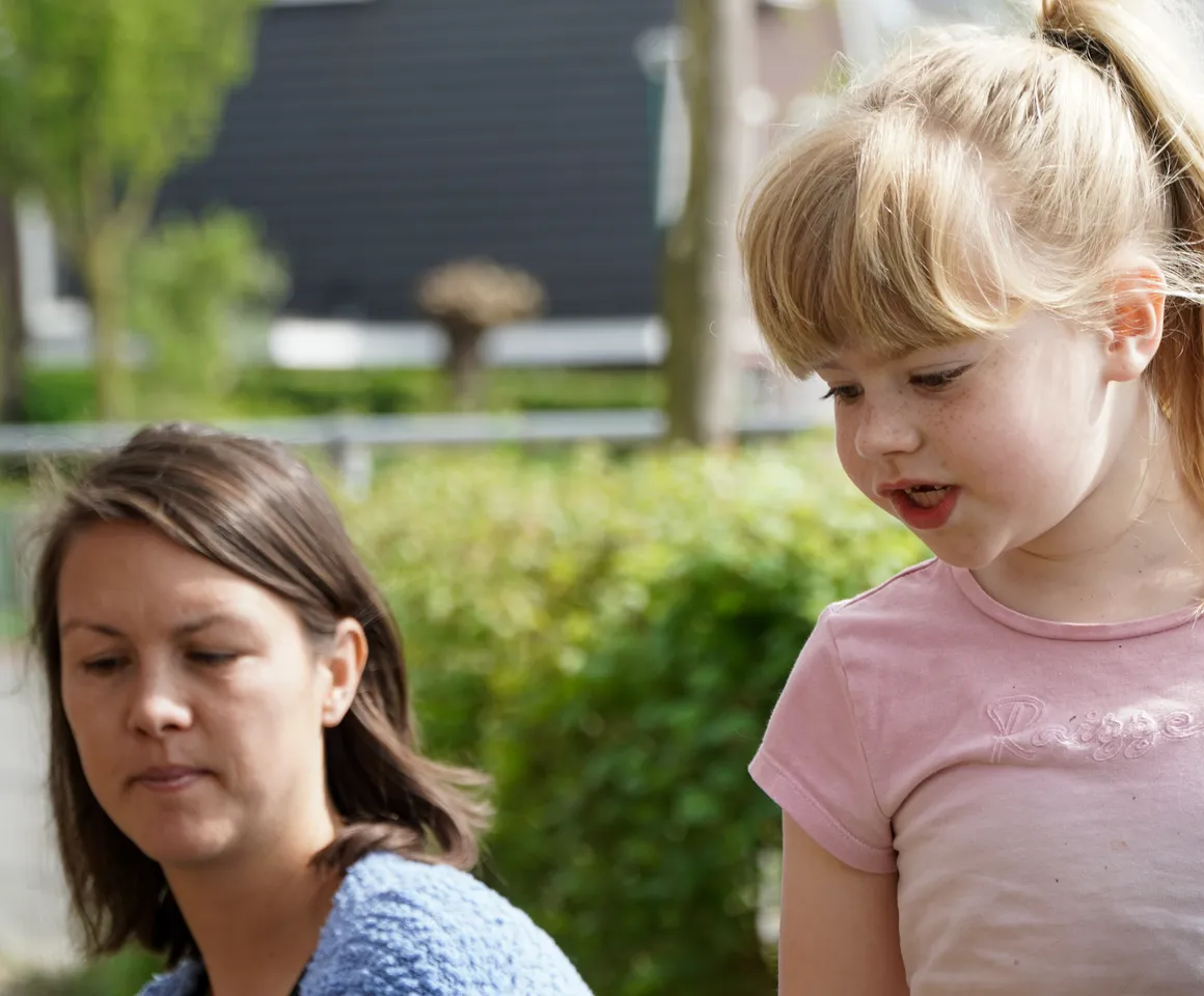 Kind voor de heg met gastouder van kinderopvang Kind&co ludens