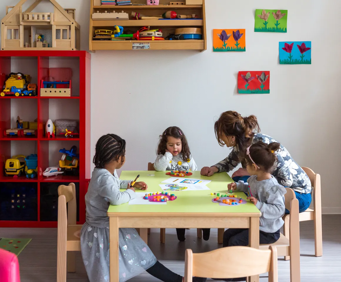 Kinderen knutselen aan tafel bij peuteropvang Johannes, Kind&co ludens