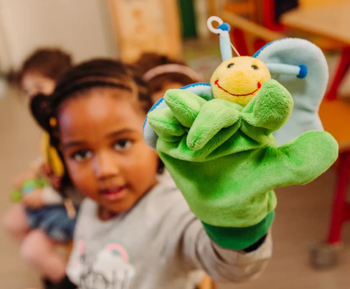 Kind van de peutergroep speelt met handpop bij kinderopvang Kind&co ludens