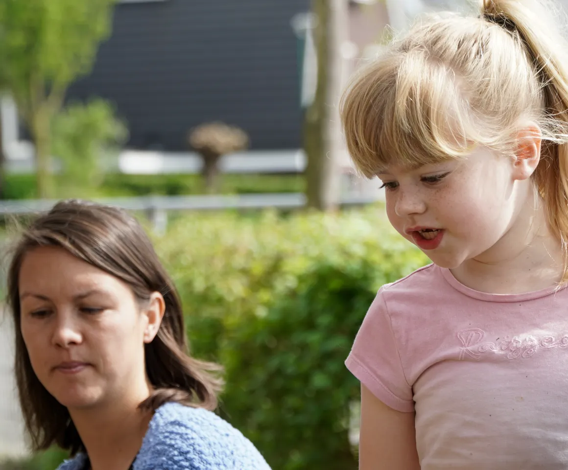 Kind voor de heg met gastouder van kinderopvang Kind&co ludens