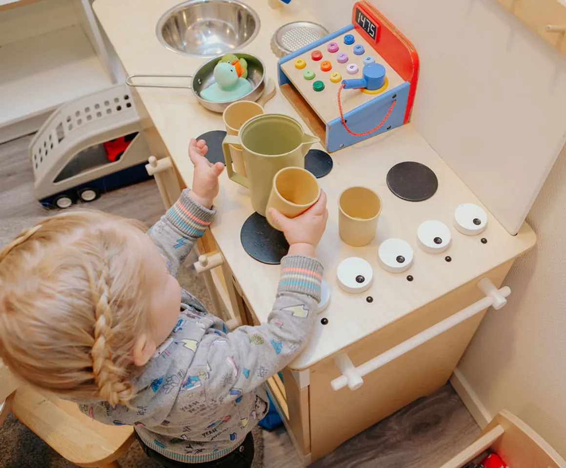 Kind speelt met het kinderkeukentje bij kinderdagverblijf De Tuinkabouter, kinderopvang Kind&co ludens