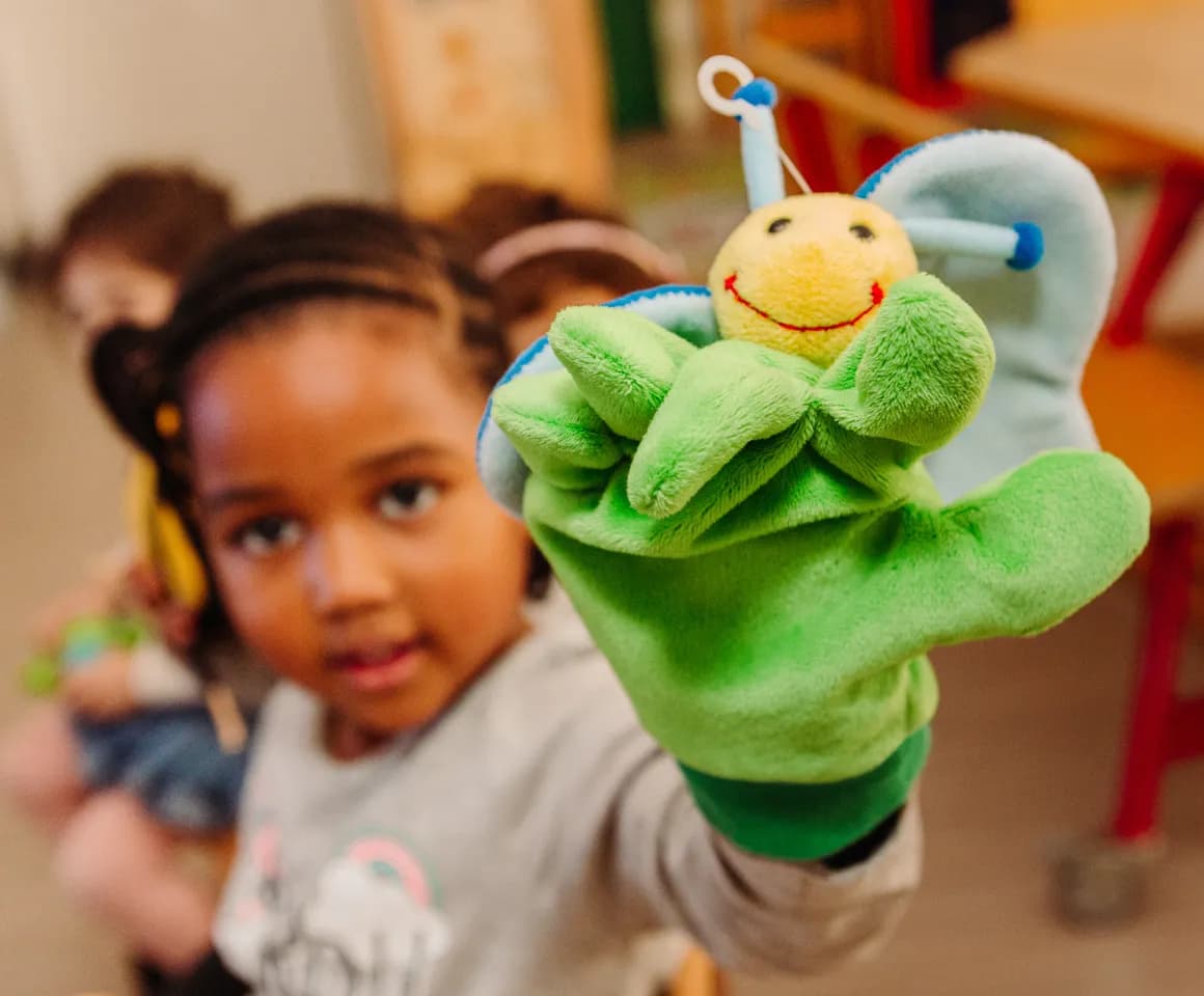 Kind van de peutergroep speelt met handpop bij kinderopvang Kind&co ludens