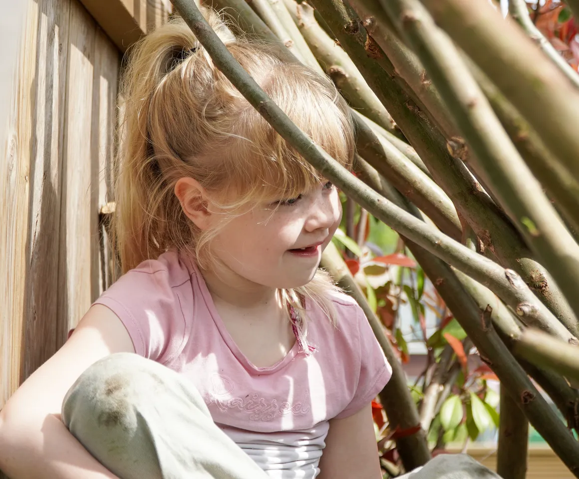 Kind speelt buiten in Wilgentakken huisje bij gastouder van kinderopvang Kind&co ludens
