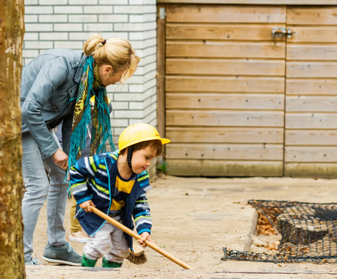 Kind speelt buiten met zand samen met pedagogisch medewerker bij KDV Utrecht Villa Kakelbont van kinderopvang Kind&co ludens