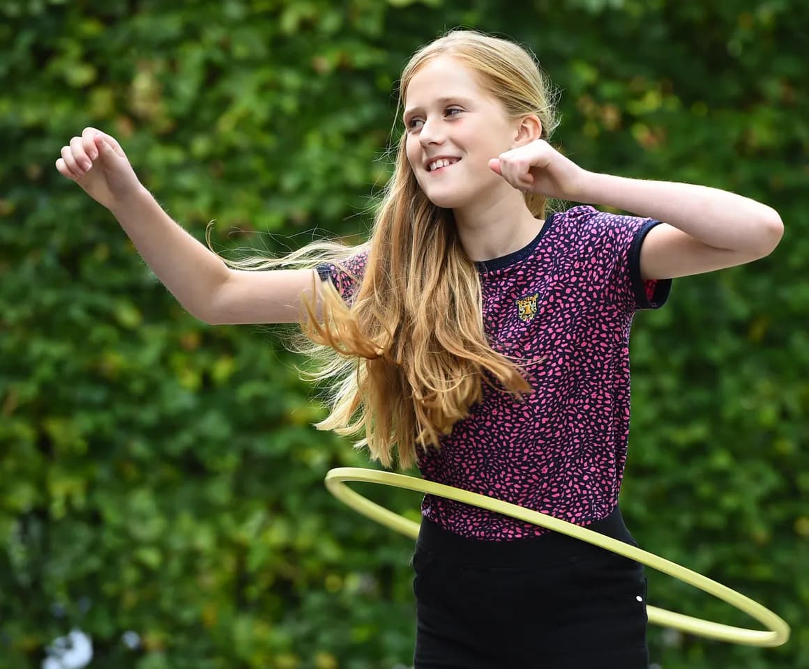 Kind van de BSO hoepelt buiten bij kinderopvang Kind&co ludens