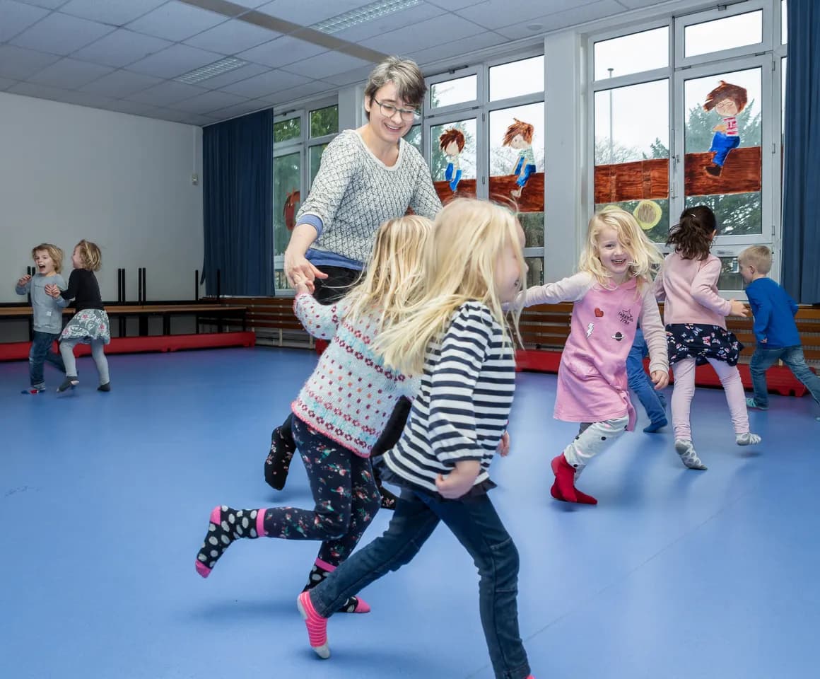 Kinderen van de BSO sporten samen in de gymzaal bij kinderopvang Kind&co ludens