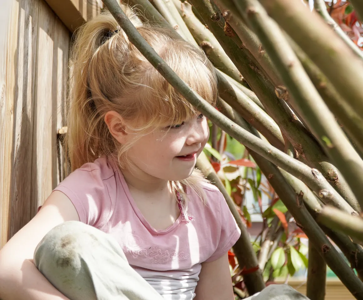 Kind speelt buiten in Wilgentakken huisje bij gastouder van kinderopvang Kind&co ludens