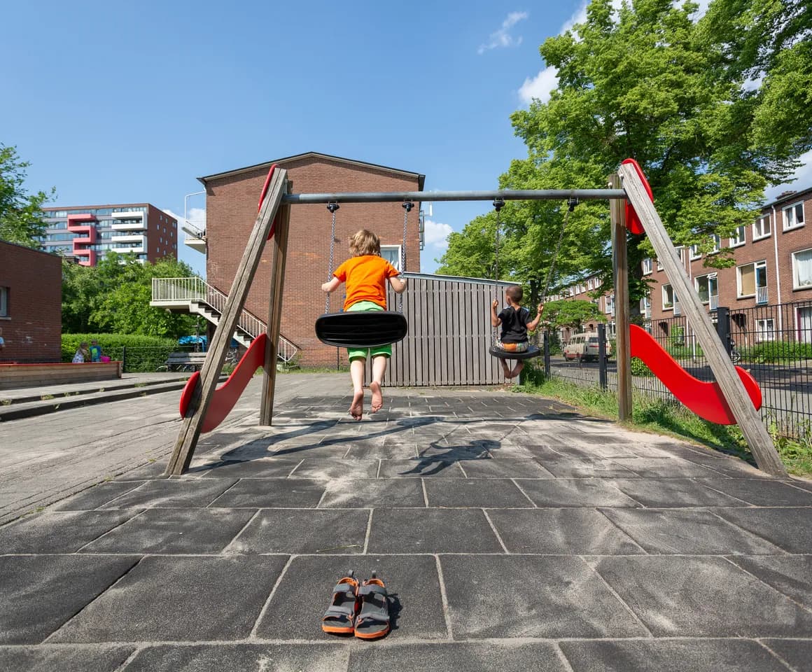 Kinderen spelen buiten op de schommel bij BSO Utrecht De Leeuw van kinderopvang Kind&co ludens