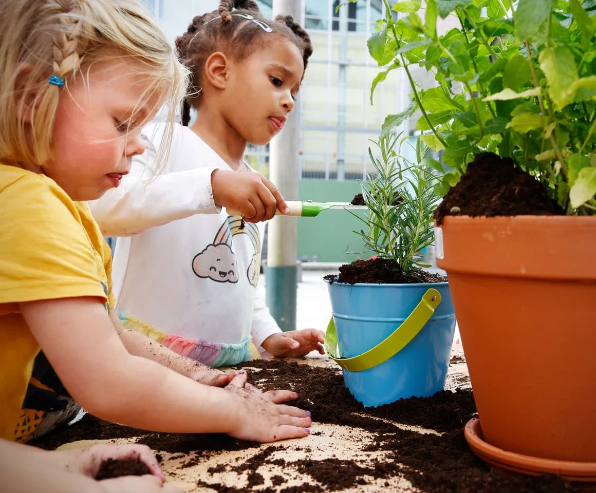 Kinderen van de peutergroep tuinieren in de moestuin bij kinderopvang Kind&co ludens