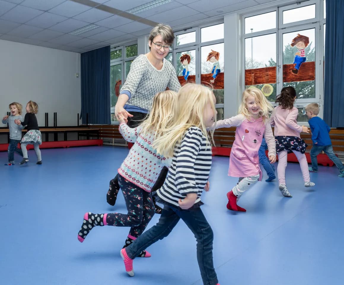 Kinderen van de BSO sporten samen in de gymzaal bij kinderopvang Kind&co ludens