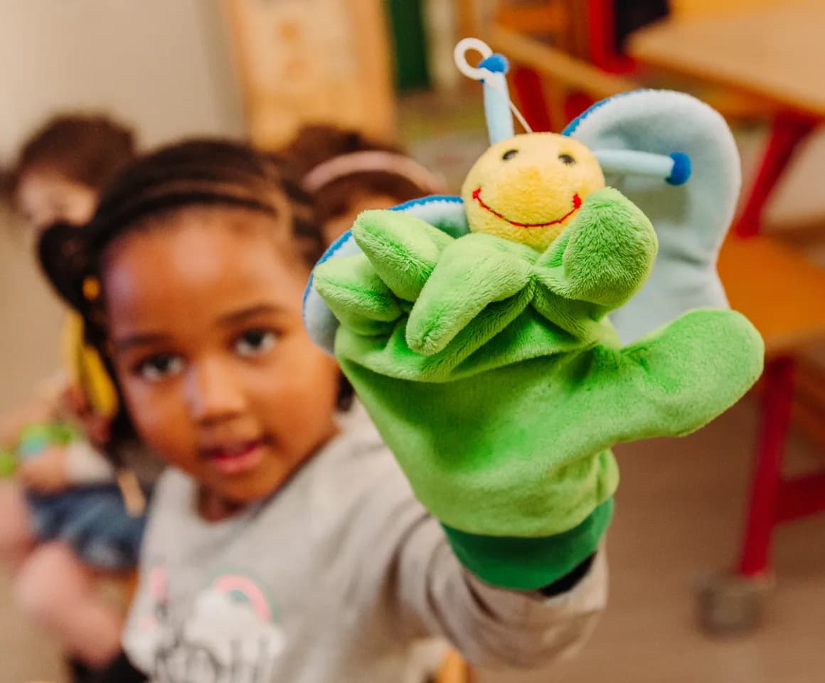 Kind van de peutergroep speelt met handpop bij kinderopvang Kind&co ludens