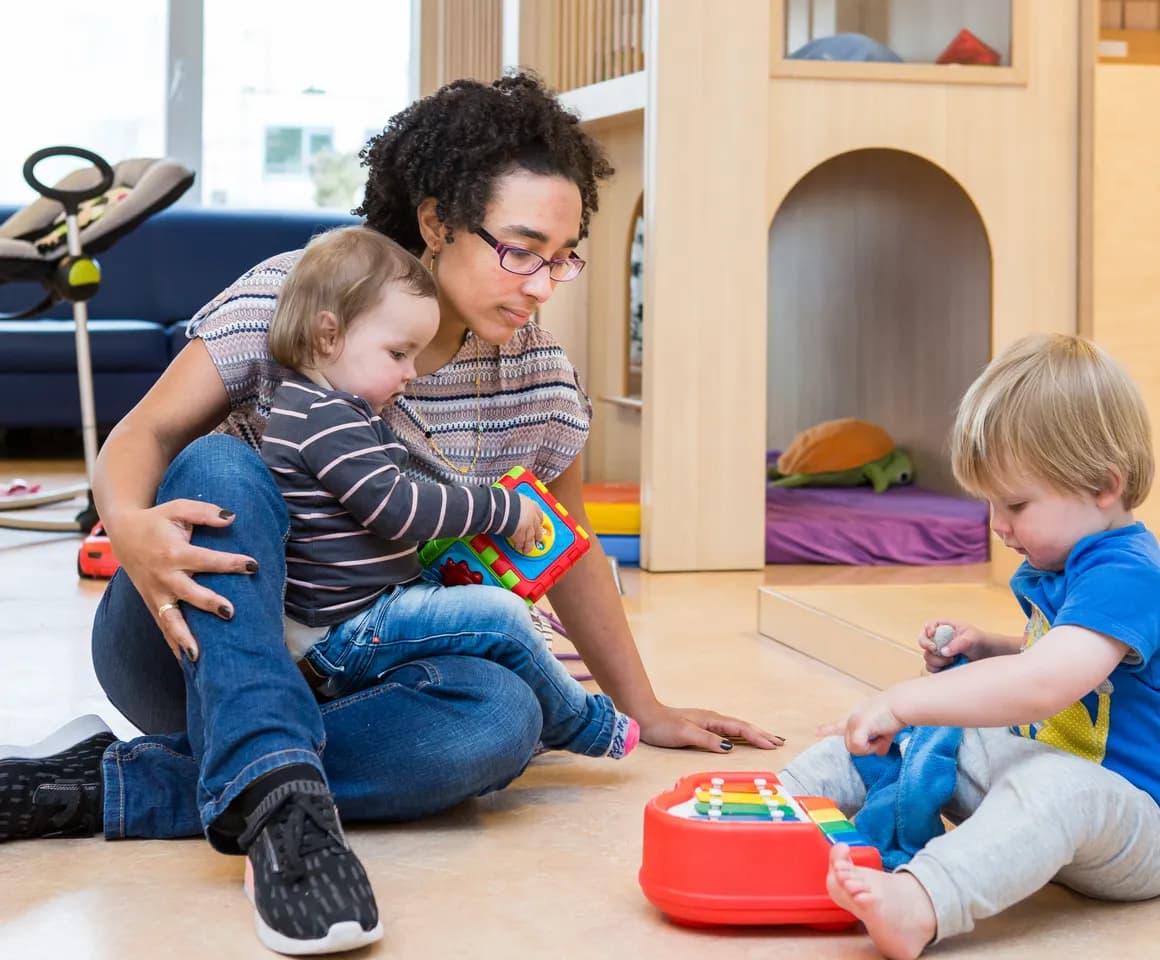 Kinderen spelen samen onder begeleiding van een pedagogisch medewerker bij kinderopvang Kind&co ludens