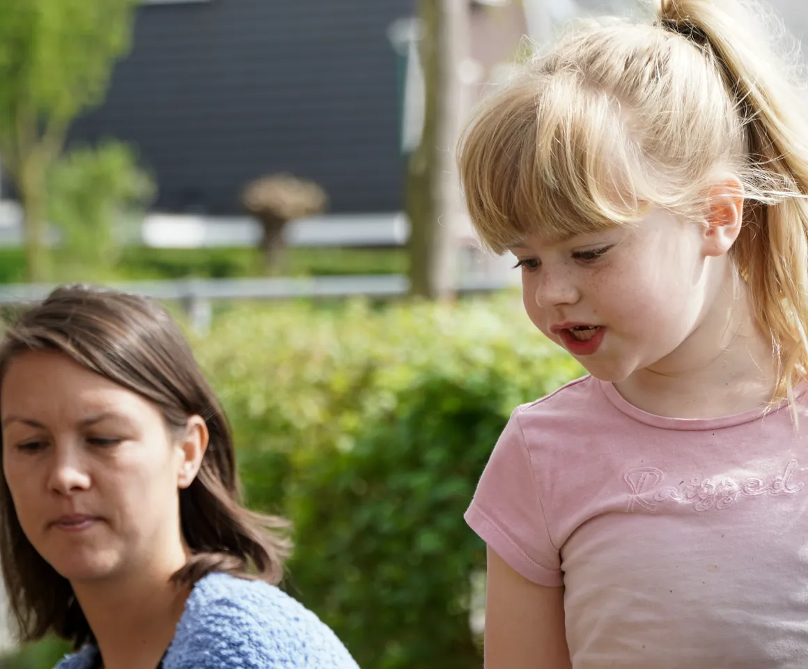 Kind voor de heg met gastouder van kinderopvang Kind&co ludens