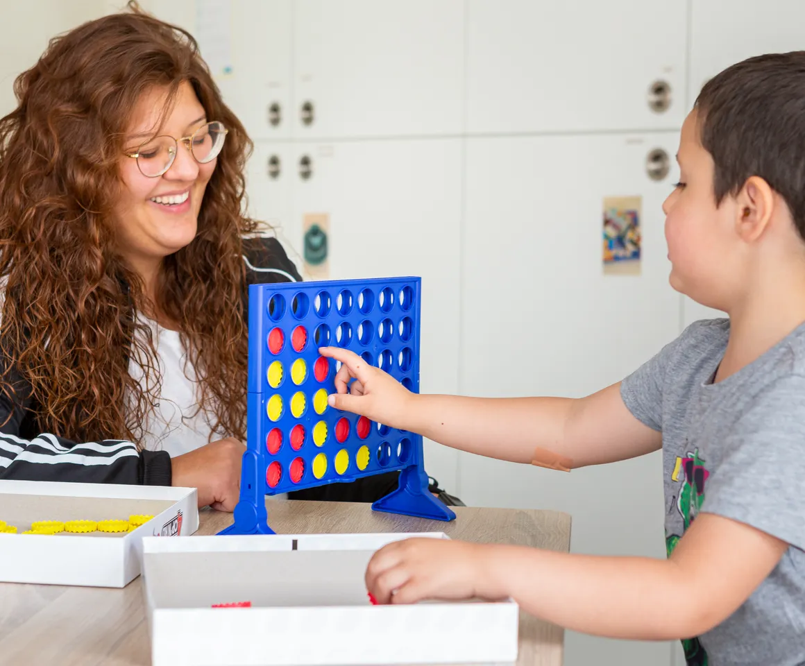 Kind speelt samen met een pedagogisch medewerker een spel bij kinderopvang Kind&co ludens