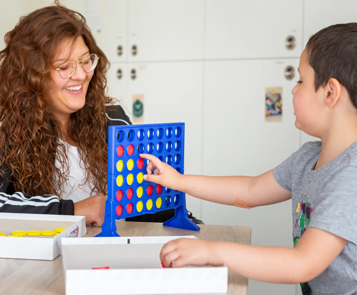 Kind speelt samen met een pedagogisch medewerker een spel bij kinderopvang Kind&co ludens