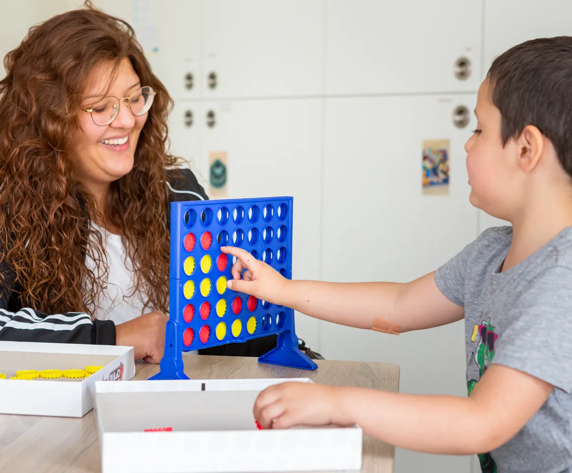Kind speelt samen met een pedagogisch medewerker een spel bij kinderopvang Kind&co ludens