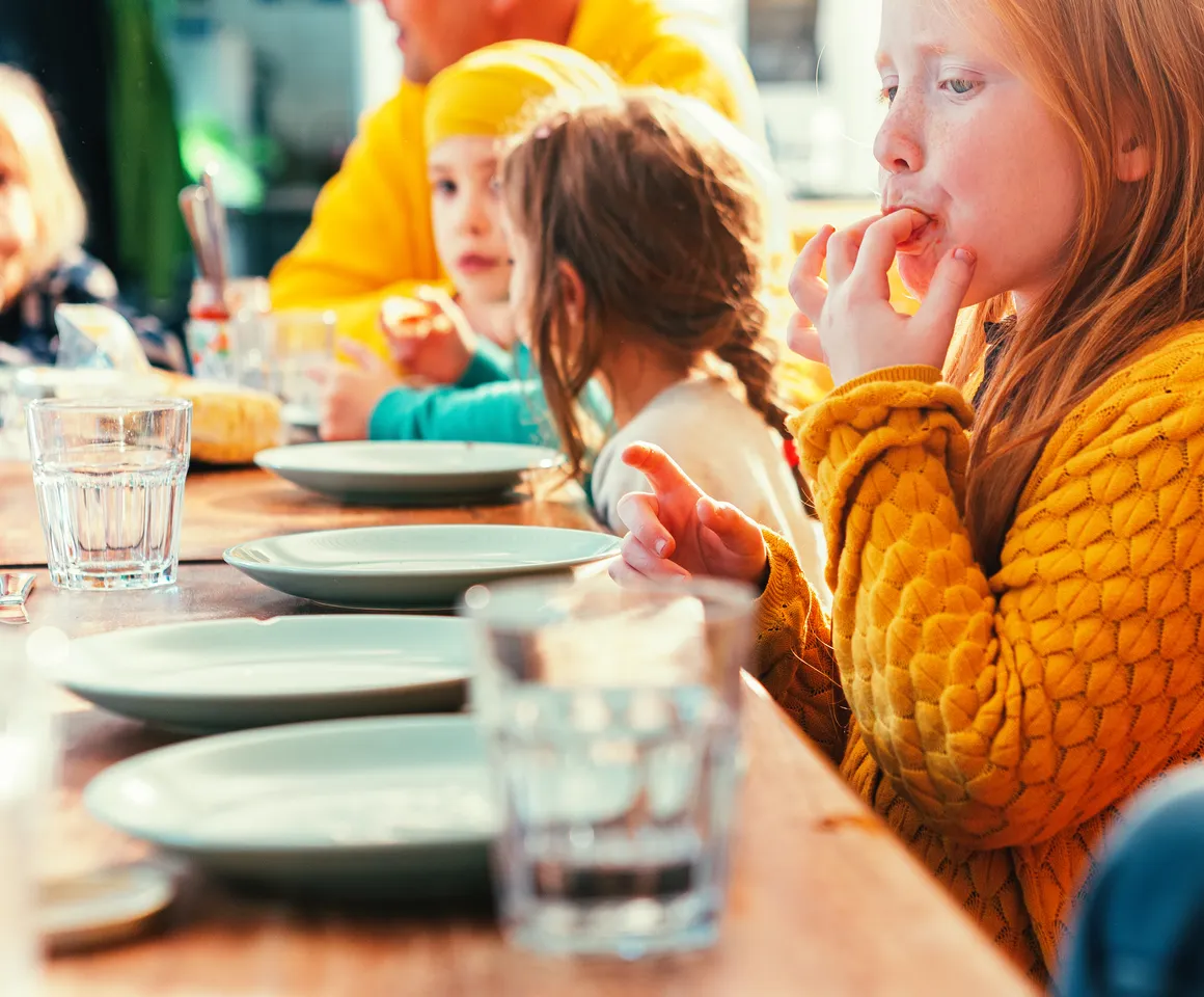Kinderen eten samen aan tafel bij kinderopvang Kind&co ludens