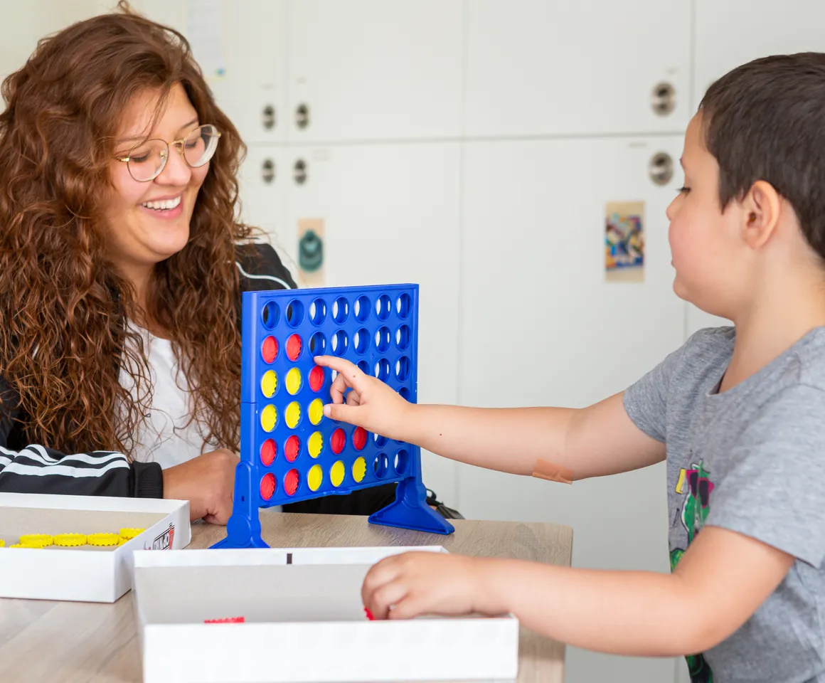 Kind speelt samen met een pedagogisch medewerker een spel bij kinderopvang Kind&co ludens