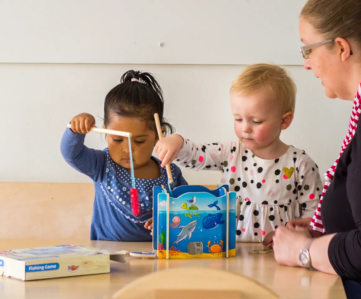 Kinderen spelen samen "Vissen" onder begeleiding van een pedagogisch medewerker bij kinderopvang Kind&co ludens