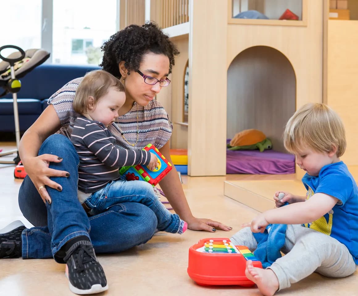 Kinderen spelen samen onder begeleiding van een pedagogisch medewerker bij kinderopvang Kind&co ludens