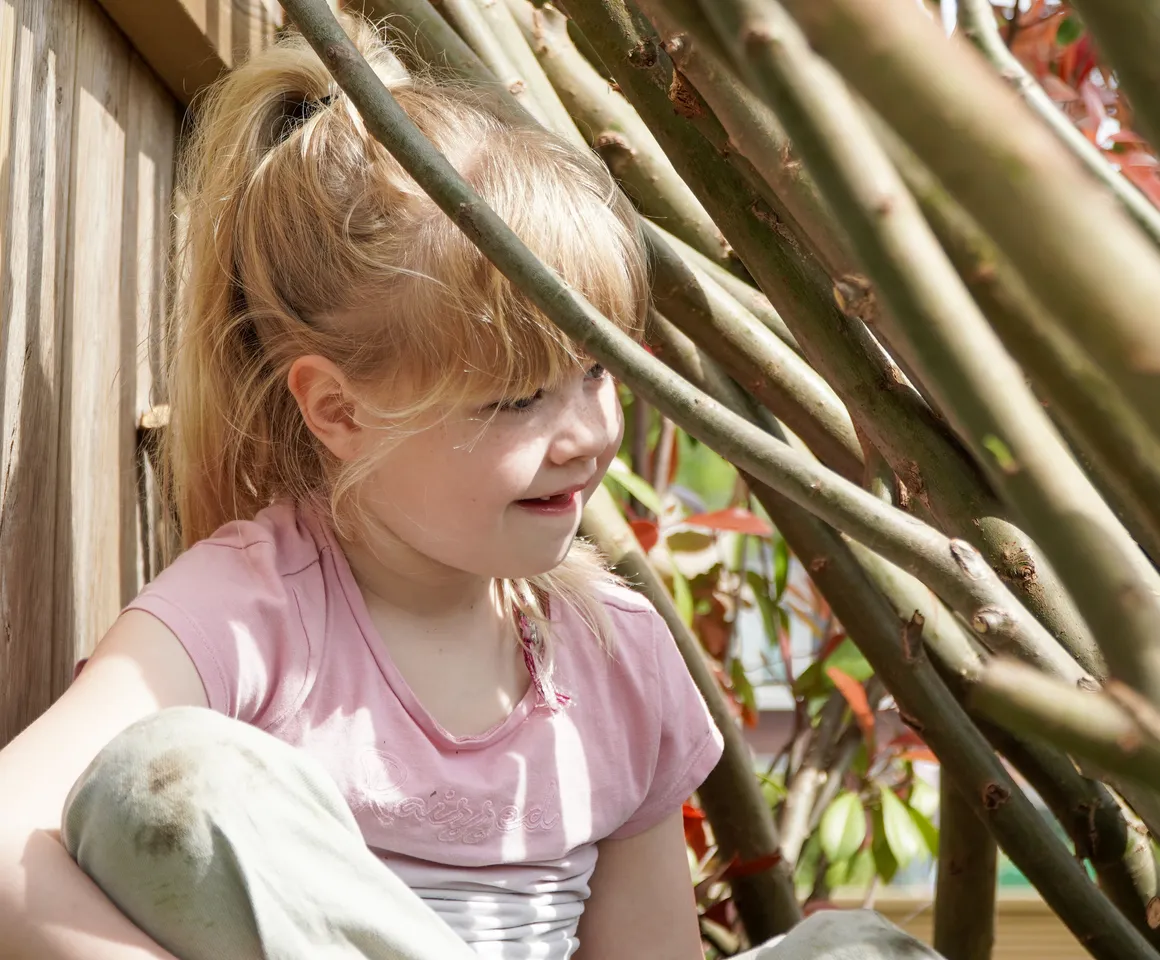 Kind speelt buiten in Wilgentakken huisje bij gastouder van kinderopvang Kind&co ludens