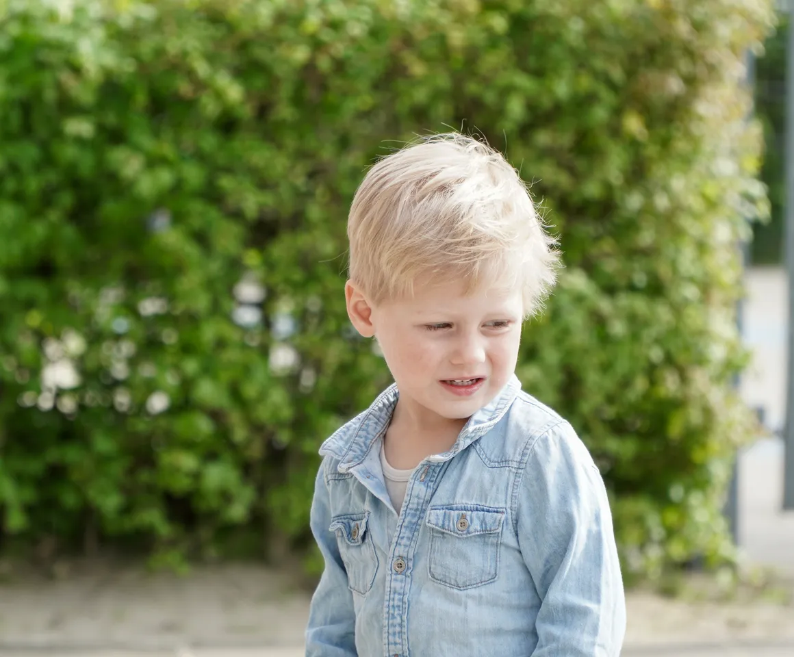 Kind staat buiten bij de heg bij gastouder van kinderopvang Kind&co ludens