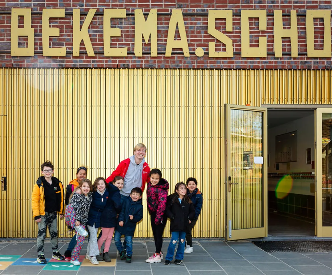 Kinderen staan lachend voor het pand van buitenschoolse opvang Villa Bekema, kinderopvang Kind&co Ludens