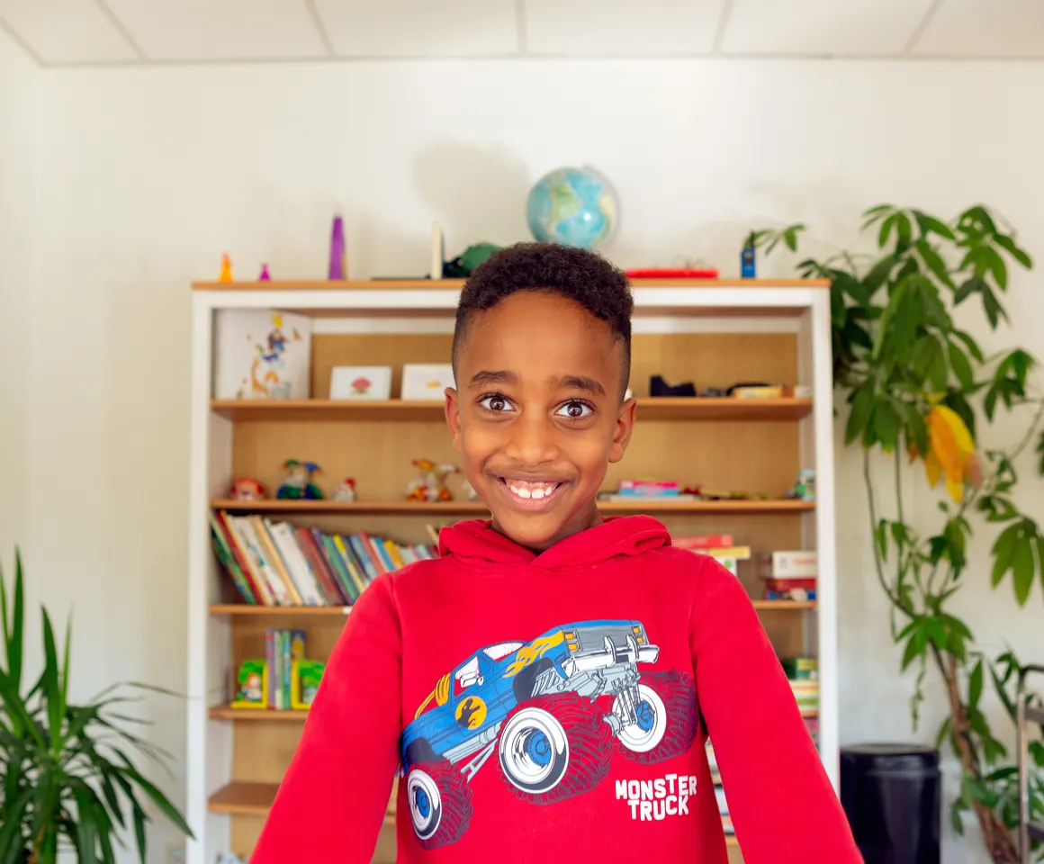 Kind bij de BSO lacht heel blij en straalt bij kinderopvang Kind&co ludens