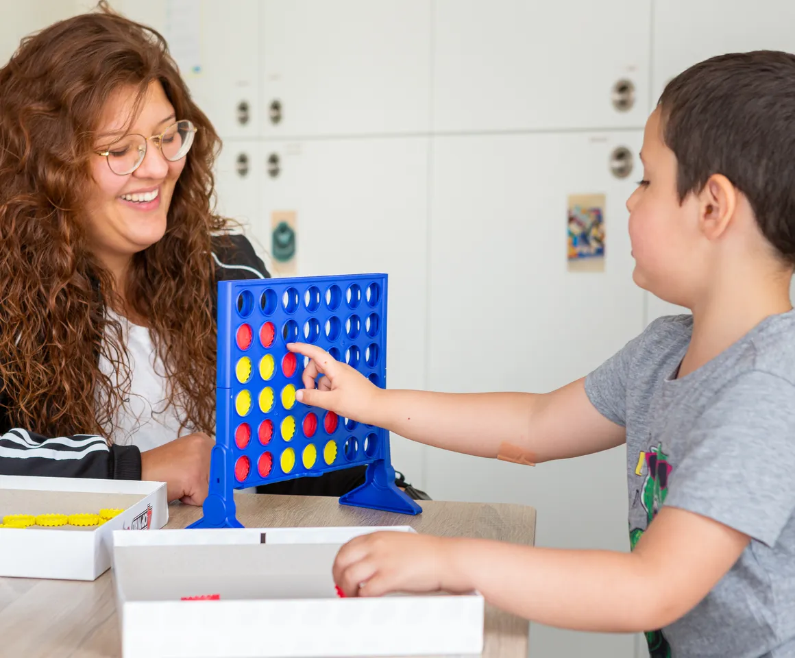 Kind speelt samen met een pedagogisch medewerker een spel bij kinderopvang Kind&co ludens