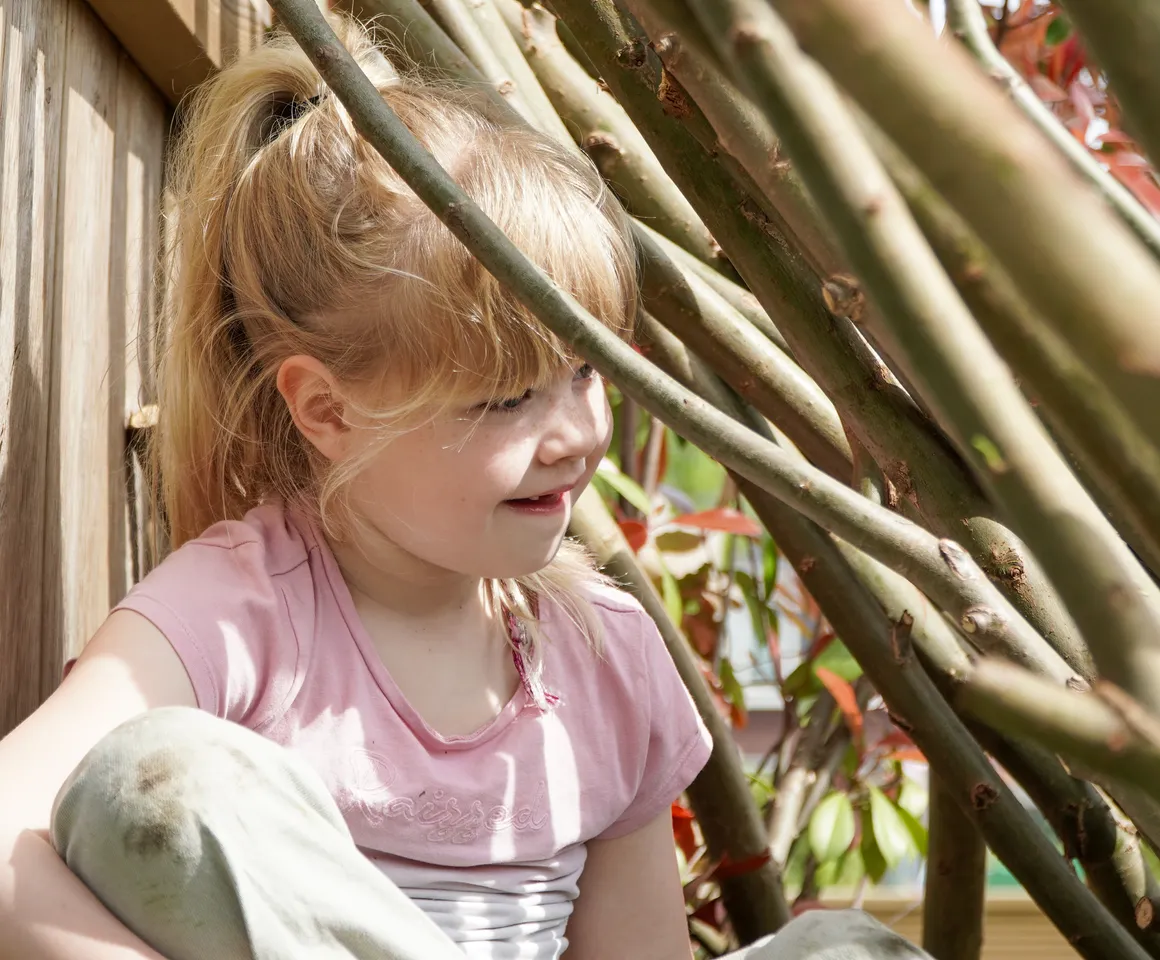 Kind speelt buiten in Wilgentakken huisje bij gastouder van kinderopvang Kind&co ludens